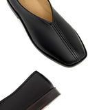 Close up of the black slippers, showing texture of the leather fabric