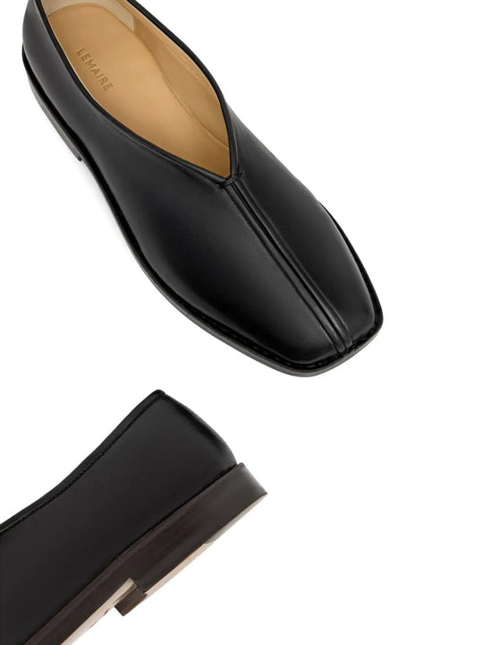 Close up of the black slippers, showing texture of the leather fabric