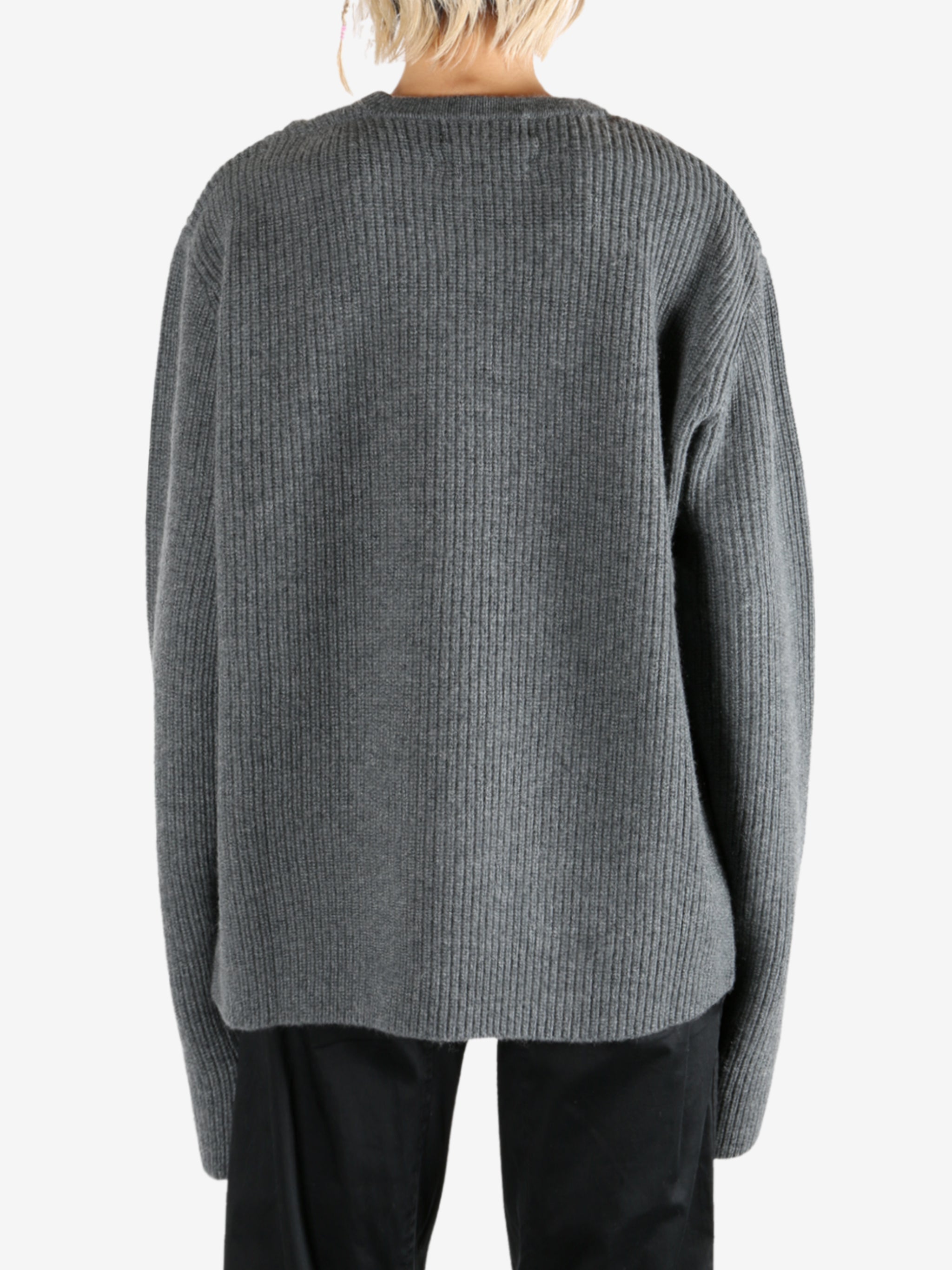 Grey knitwear worn by a person, showing the knitwear's fit