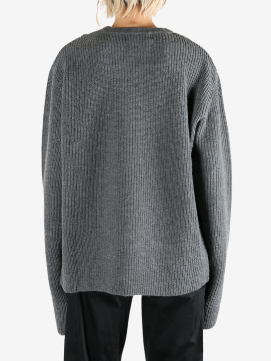 Grey knitwear worn by a person, showing the knitwear's fit