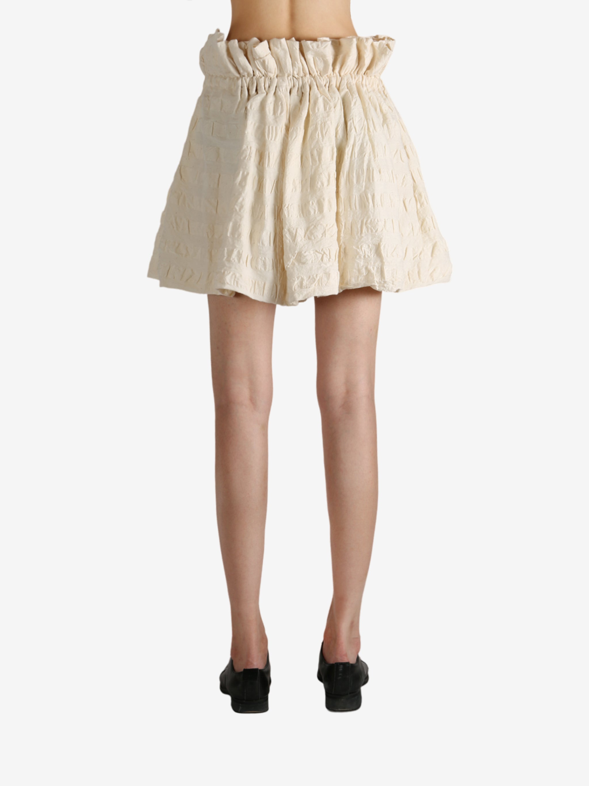 White skirt worn by a person, showing the skirt fit