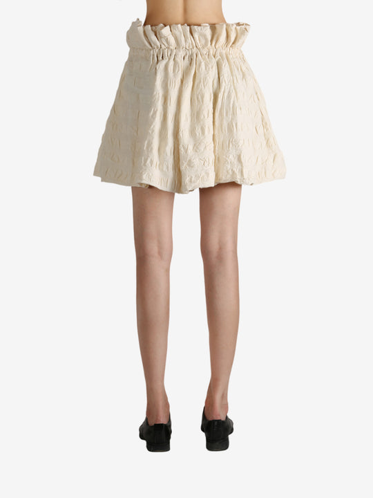 White skirt worn by a person, showing the skirt fit