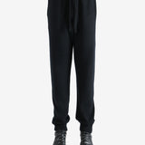 Black pants worn by a person, showing the pants' fit