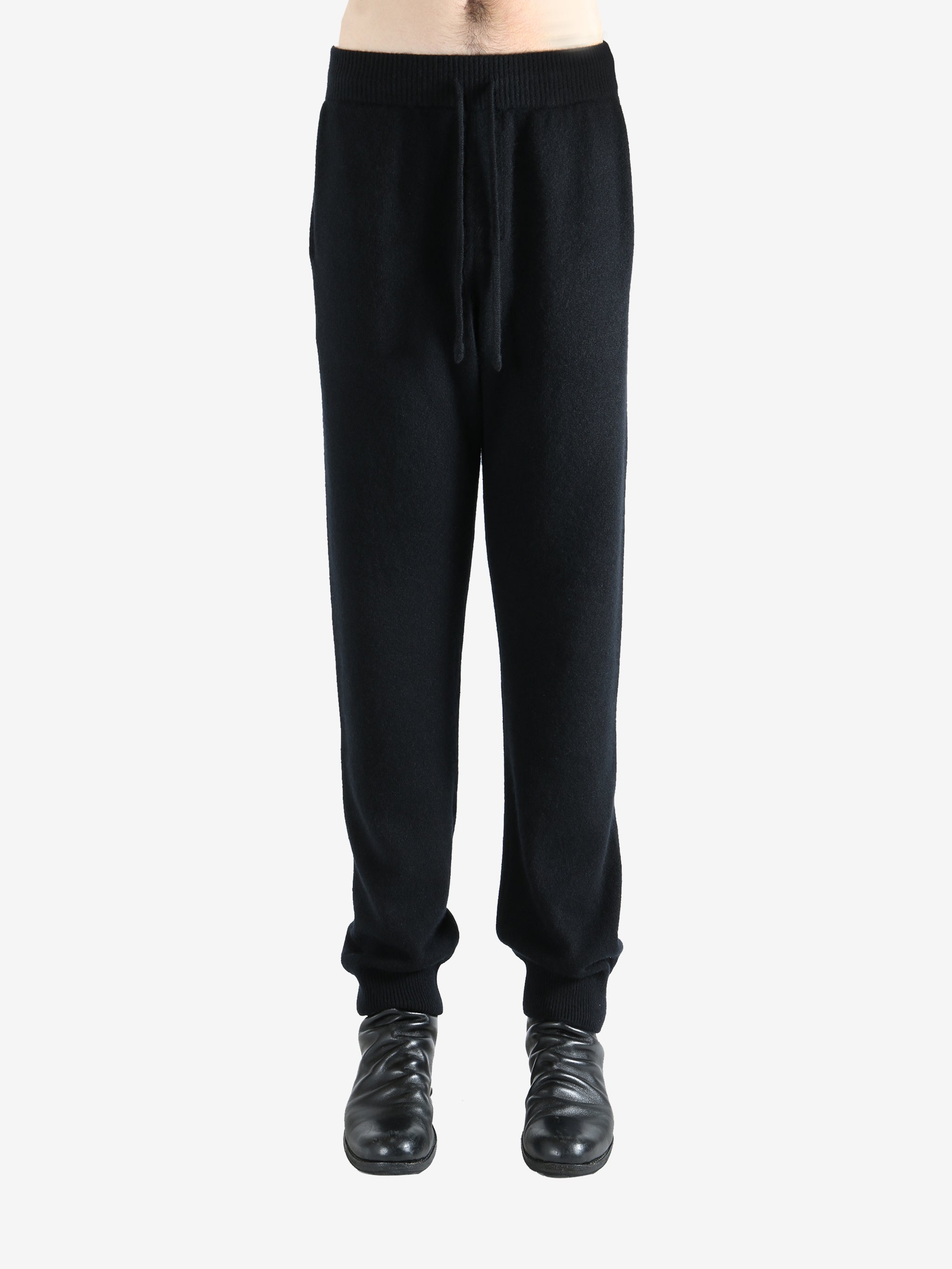 Black pants worn by a person, showing the pants' fit