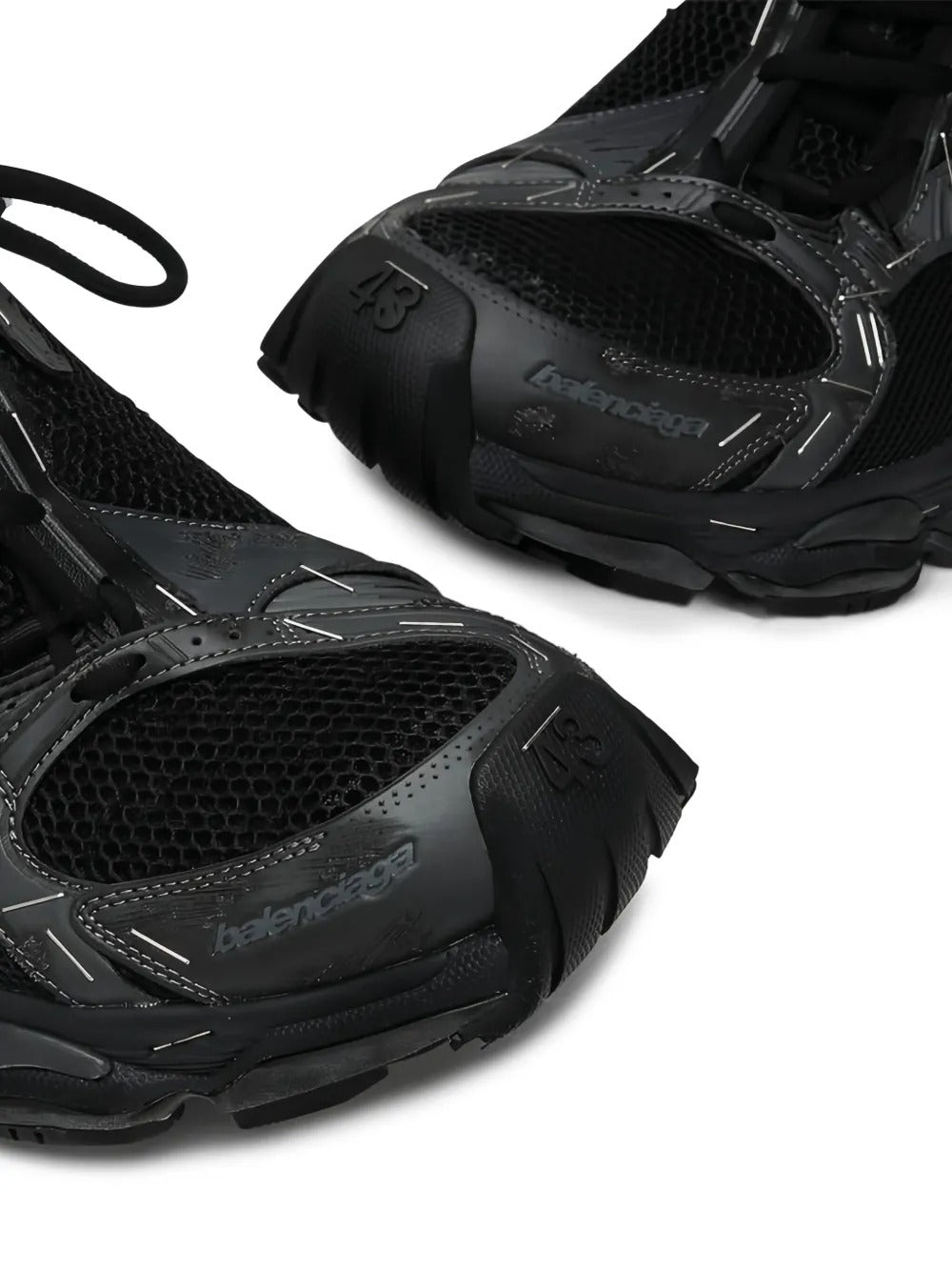 Close up of the black sneakers, showing texture of the polyester and polyurethane fabric