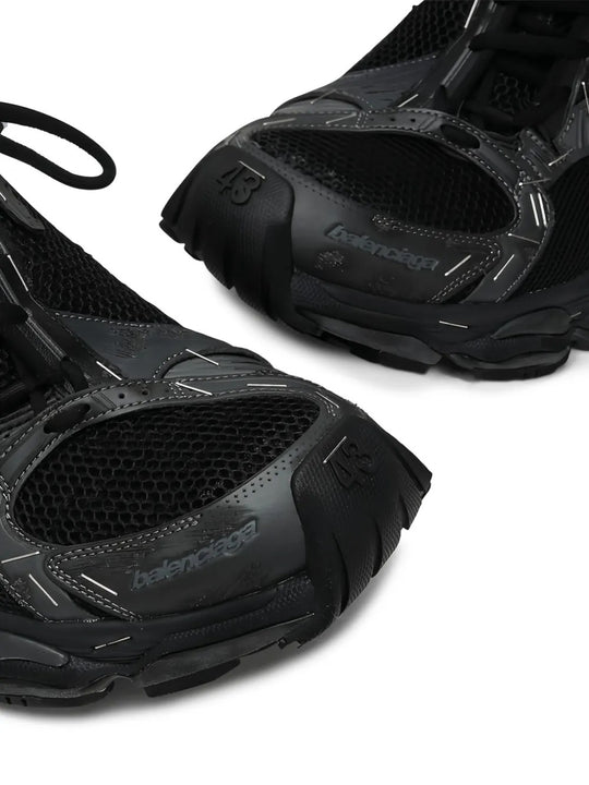Close up of the black sneakers, showing texture of the polyester and polyurethane fabric