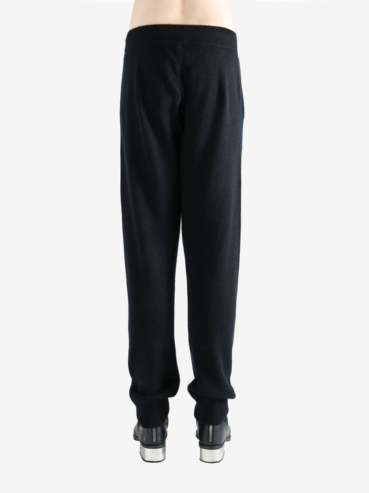 Black pants worn by a person, showing the pants' fit