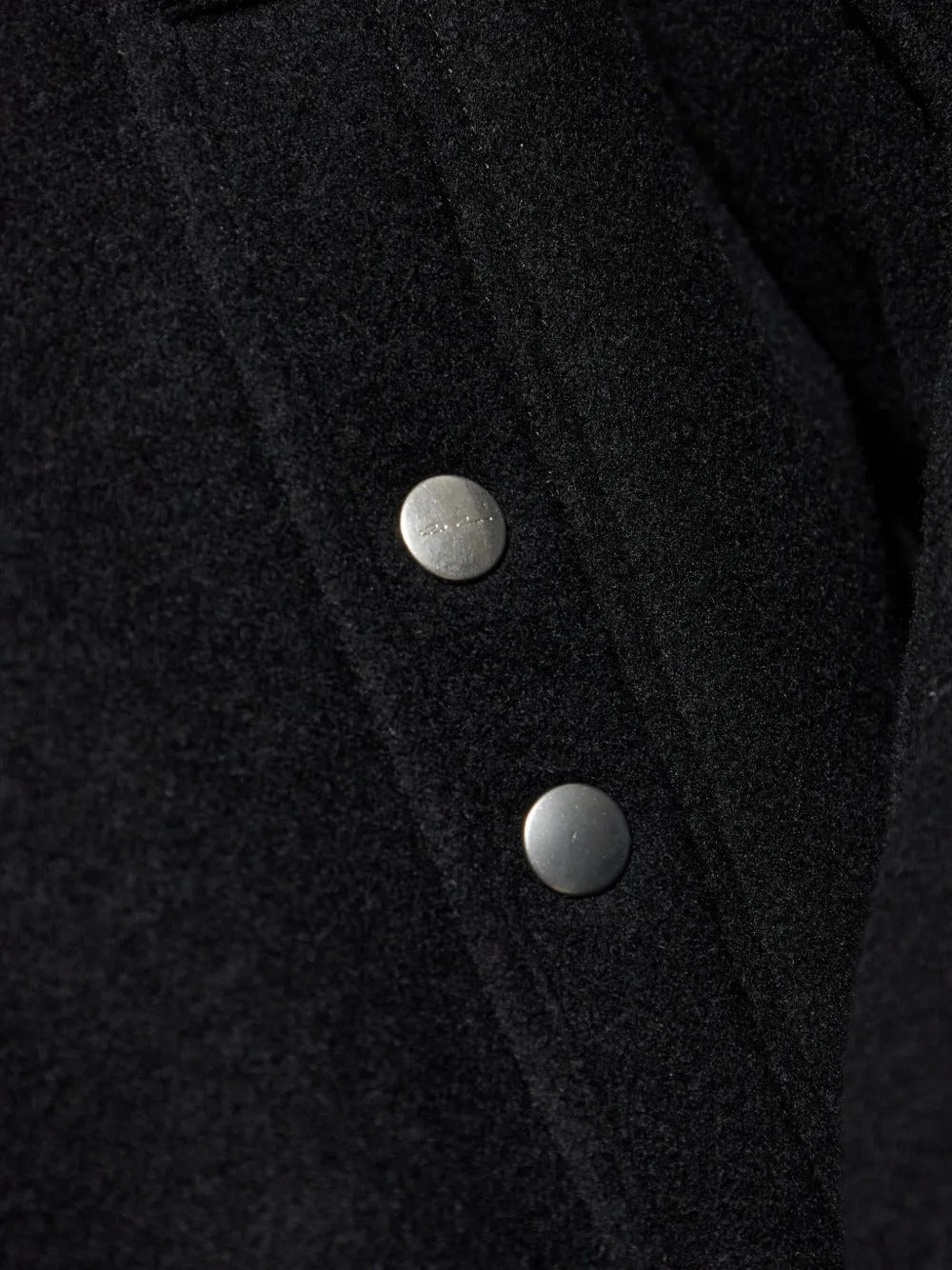 Close up of the black jacket, showing texture of the wool fabric