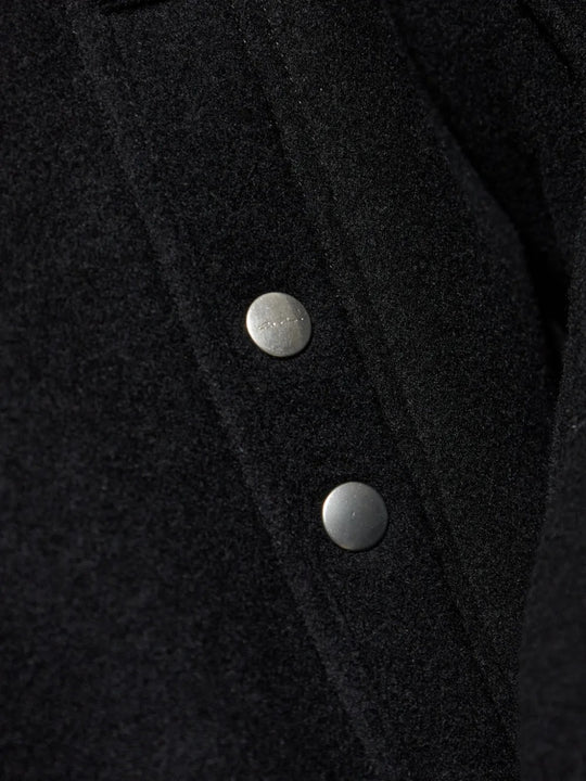 Close up of the black jacket, showing texture of the wool fabric