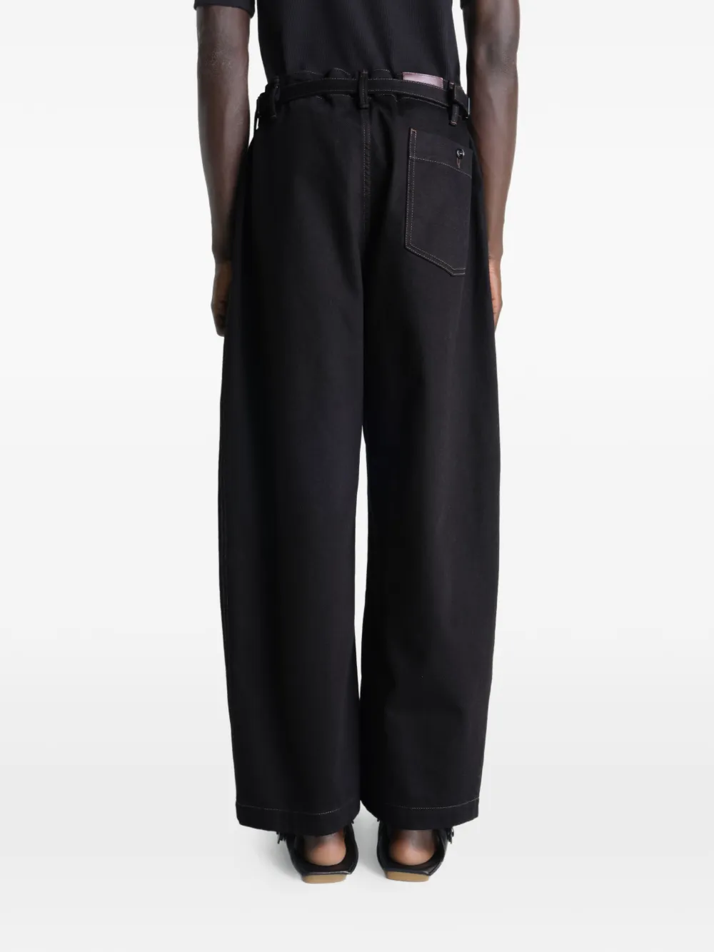 Black pants worn by a person, showing the pants fit