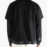 Black t-shirts worn by a person, showing the t-shirts fit