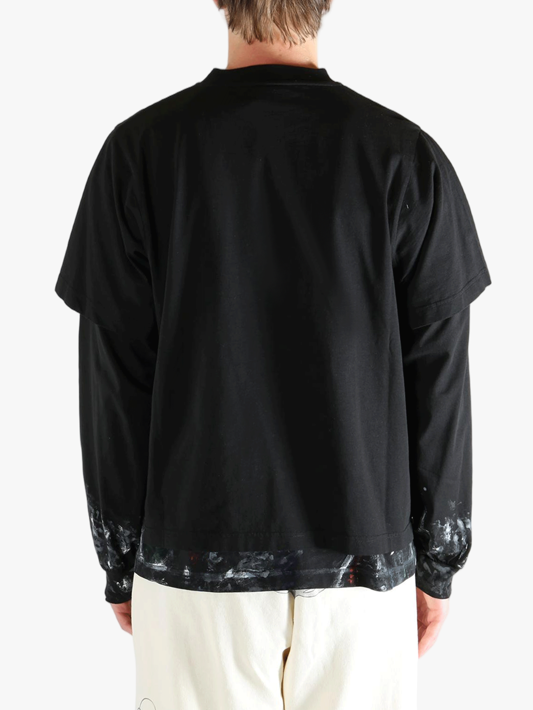 Black t-shirts worn by a person, showing the t-shirts fit