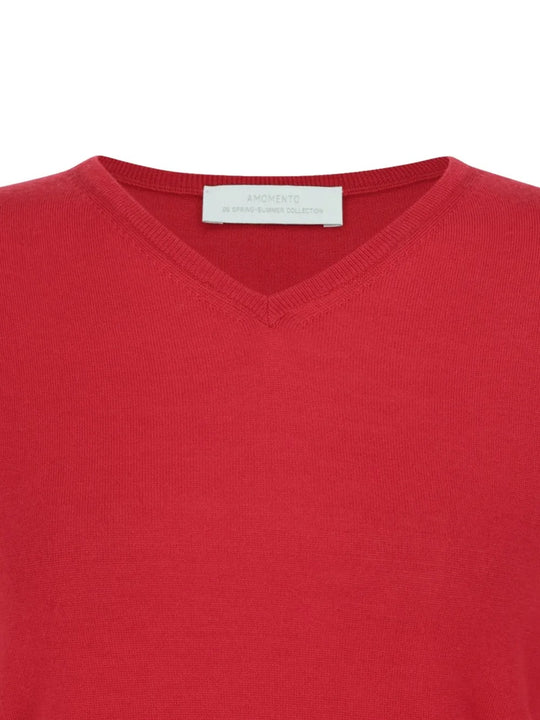 Close up of red knitwear, showing texture of the wool fabric
