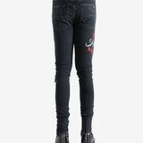 Black jeans worn by a person, showing the jeans fit