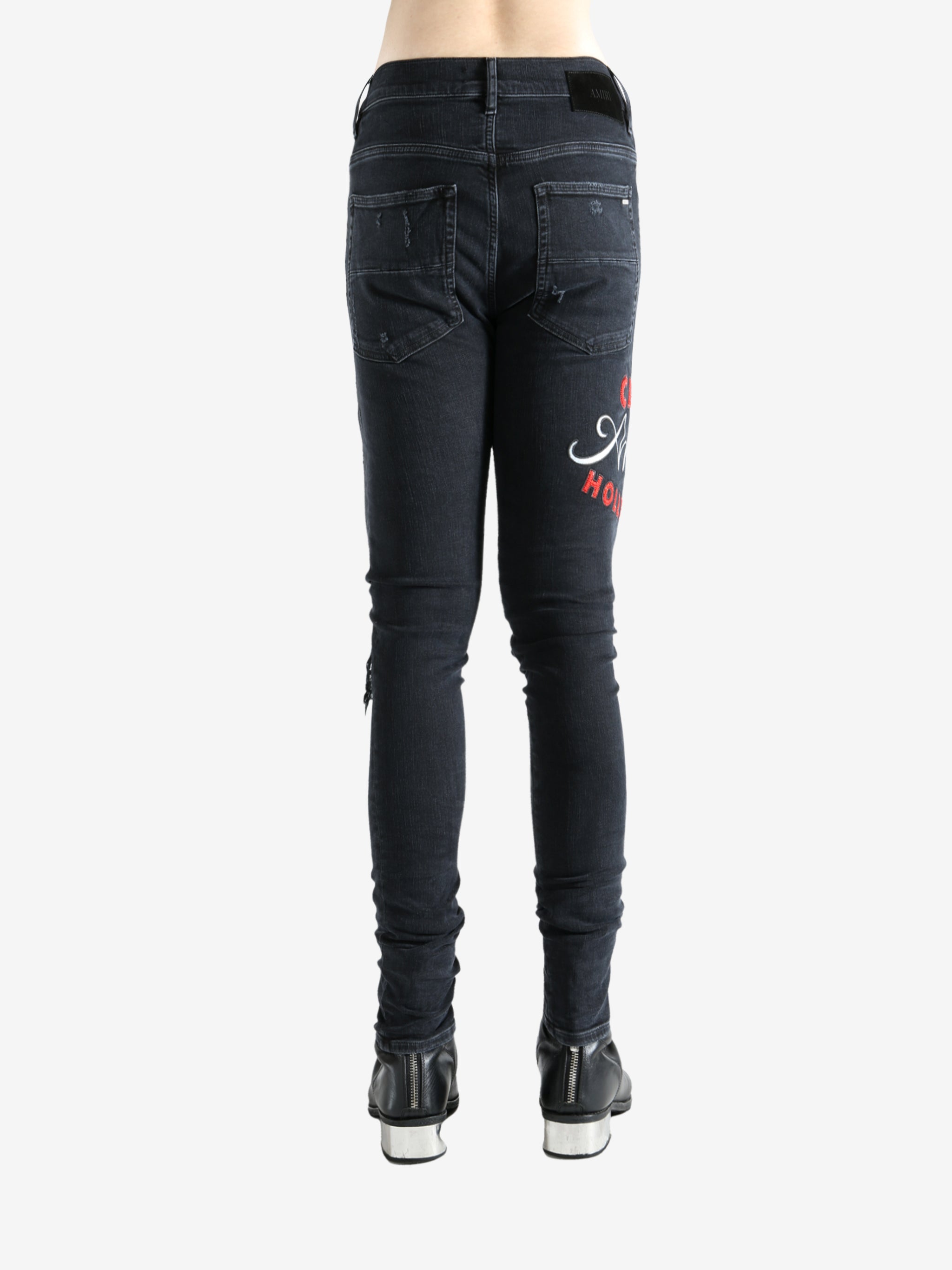Black jeans worn by a person, showing the jeans fit