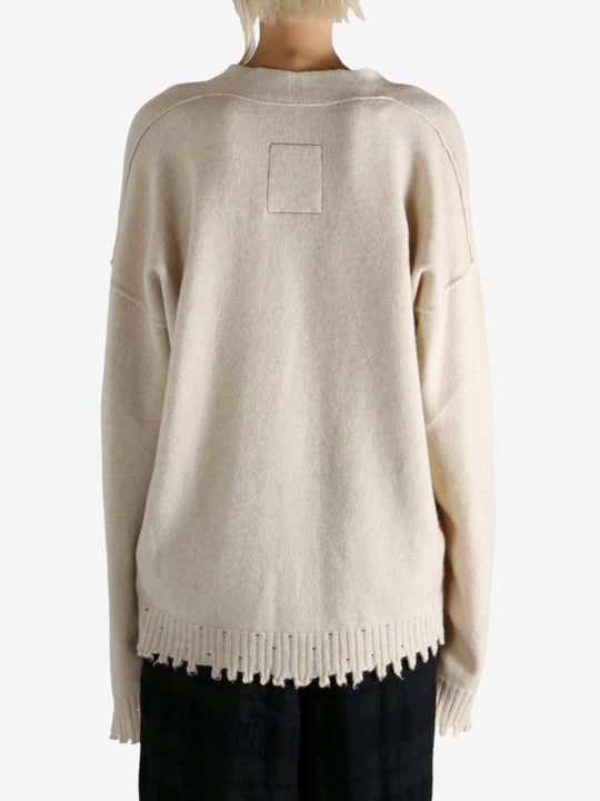 Tan knitwear worn by a person, showing the knitwear fit