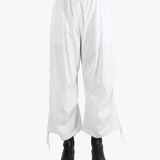 White pants worn by a person, showing the pants' fit