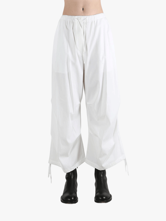 White pants worn by a person, showing the pants' fit