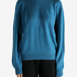 Blue sweater worn by a person, showing the sweater's fit