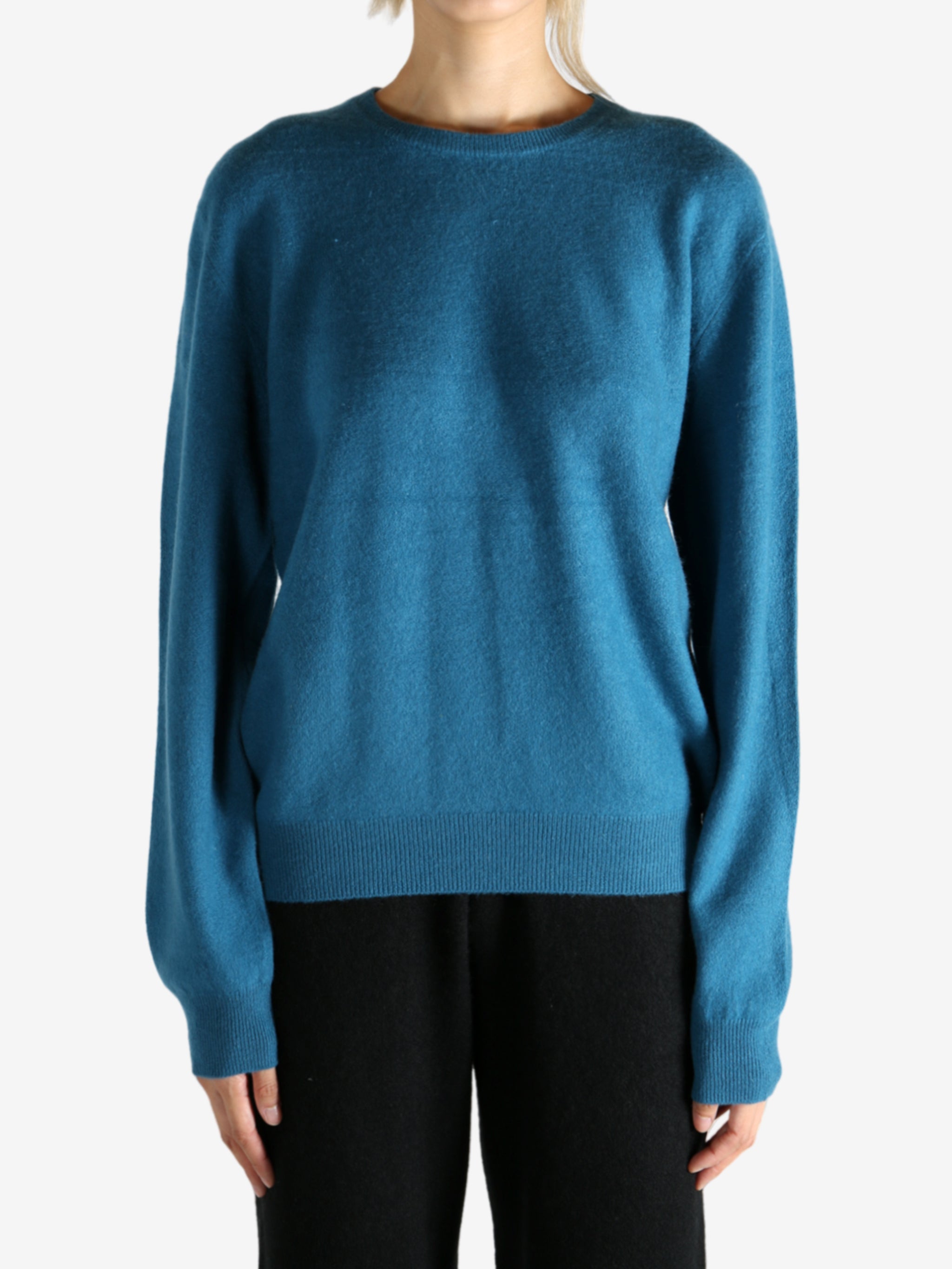 Blue sweater worn by a person, showing the sweater's fit