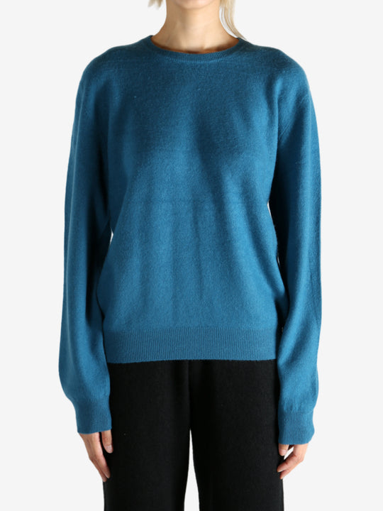 Blue sweater worn by a person, showing the sweater's fit