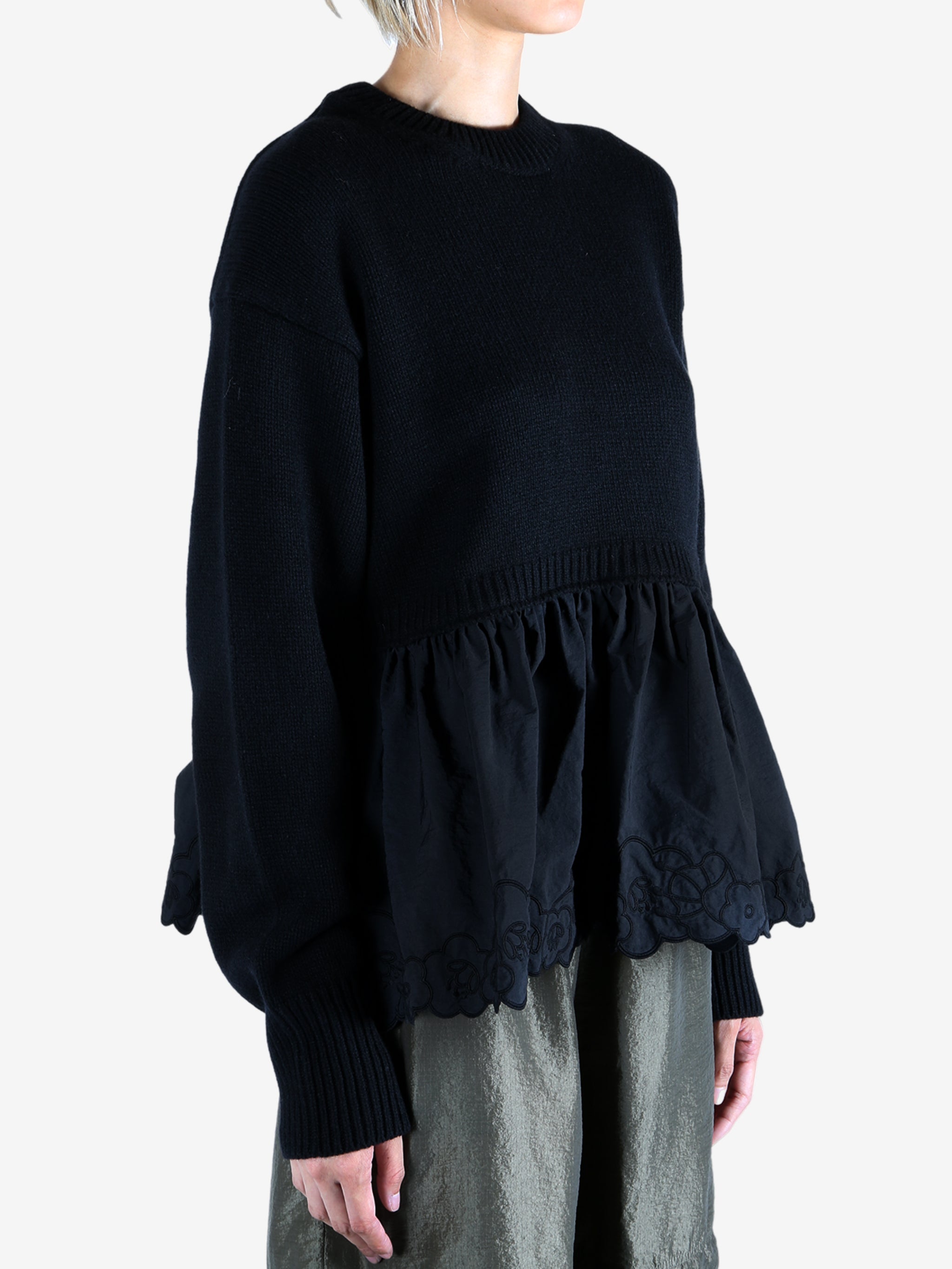 Black sweat worn by a person, showing the sweat's fit