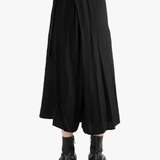 Black skirts worn by a person, showing the skirts fit