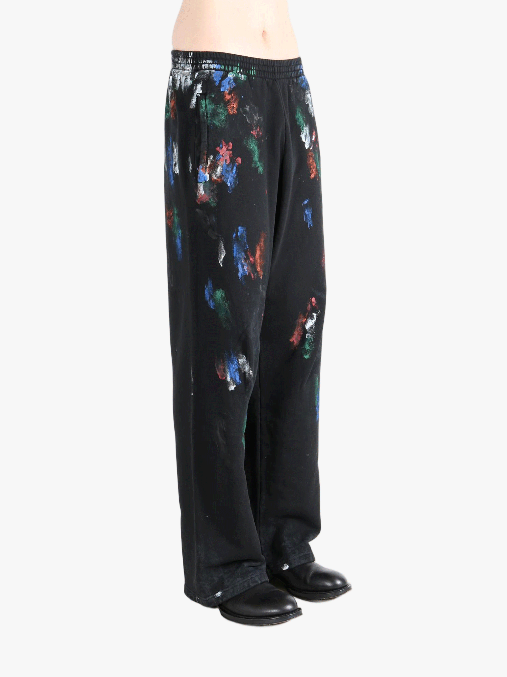 Black pants worn by a person, showing the shirt's fit