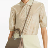 Brown bag carried by a person, showing the bag’s fit