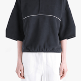 Black shirts worn by a person, showing the shirts' fit 