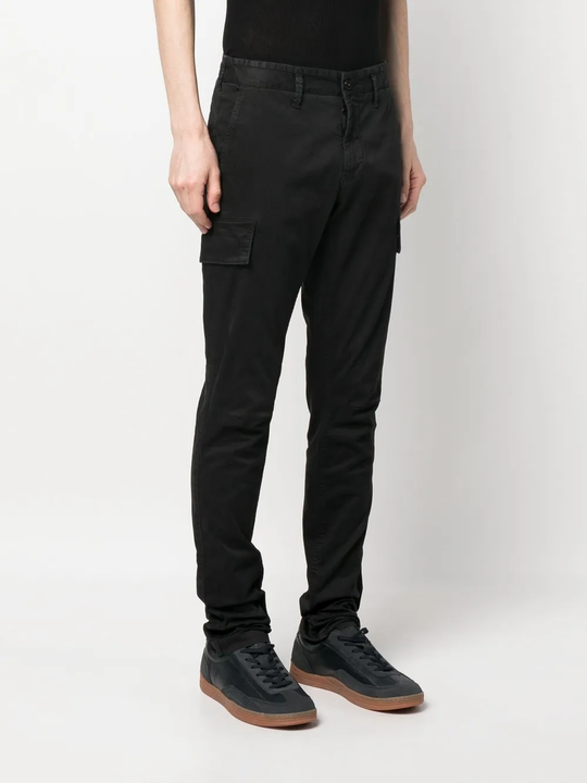 Black pants worn by a person, showing the black pants' fit