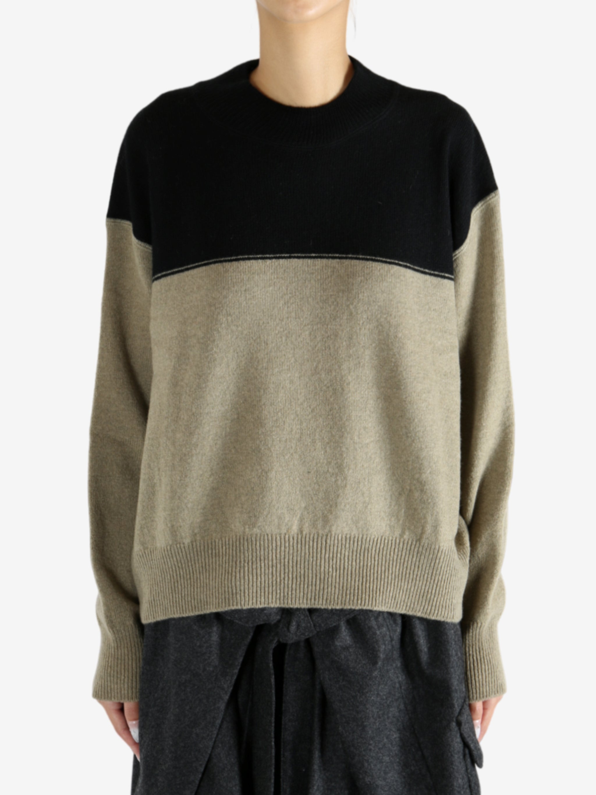 Black knitwear worn by a person, showing the knitwear fit