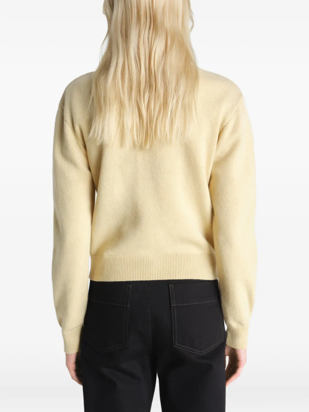 Tan knitwear worn by a person, showing the knitwear's fit