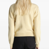 Tan knitwear worn by a person, showing the knitwear's fit