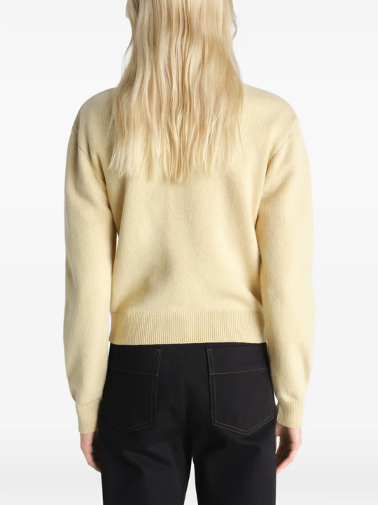 Tan knitwear worn by a person, showing the knitwear's fit