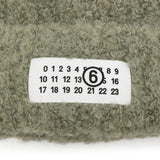Close up of Green hat, showing texture of the 65% acrylic/ 17% polyamide/ 9% viscose/ 9% wool fabric
