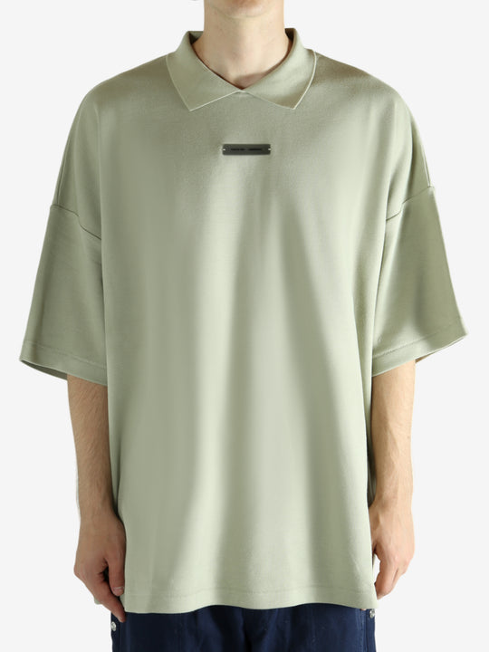 Green shirt worn by a person, showing the shirt's fit