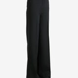 Black pants worn by a person, showing the pants' fit