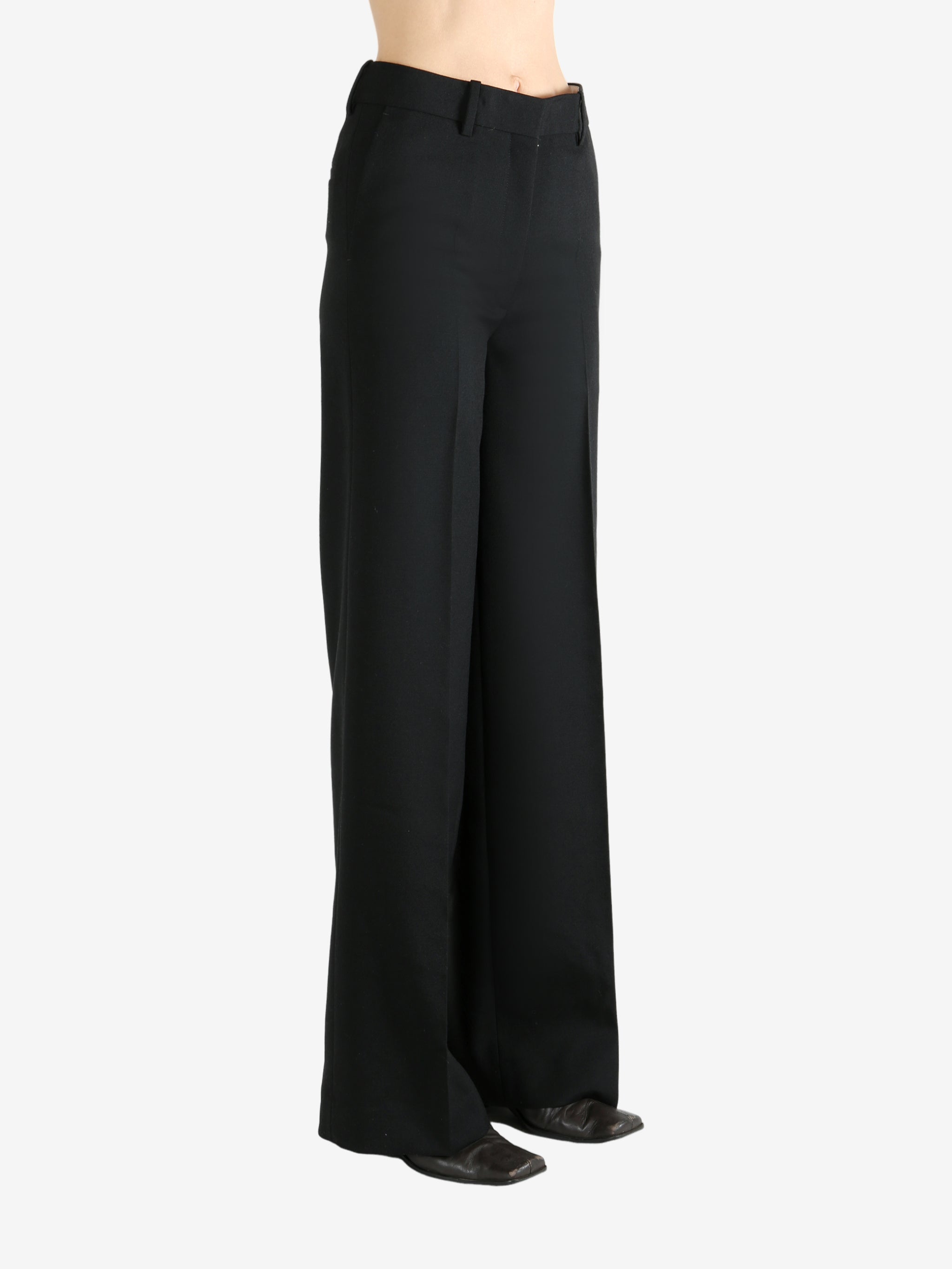 Black pants worn by a person, showing the pants' fit