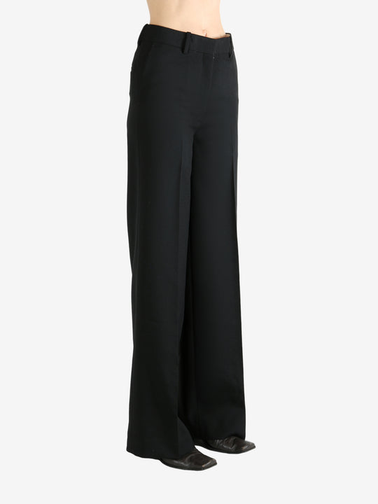 Black pants worn by a person, showing the pants' fit