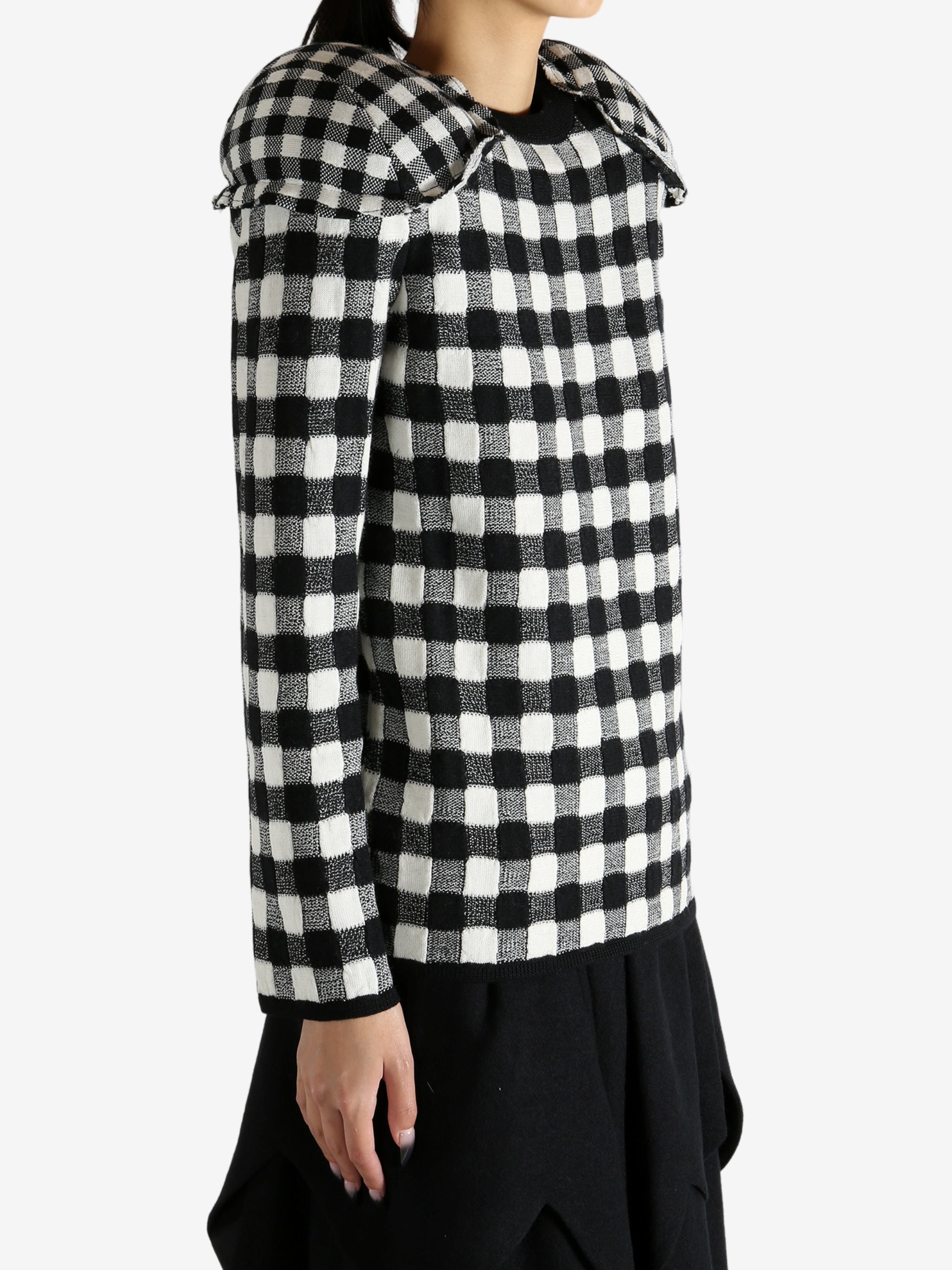 Black sweater worn by a person, showing the knitwear's fit