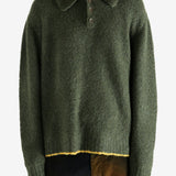 Green knitwear worn by a person, showing the knitwear's fit