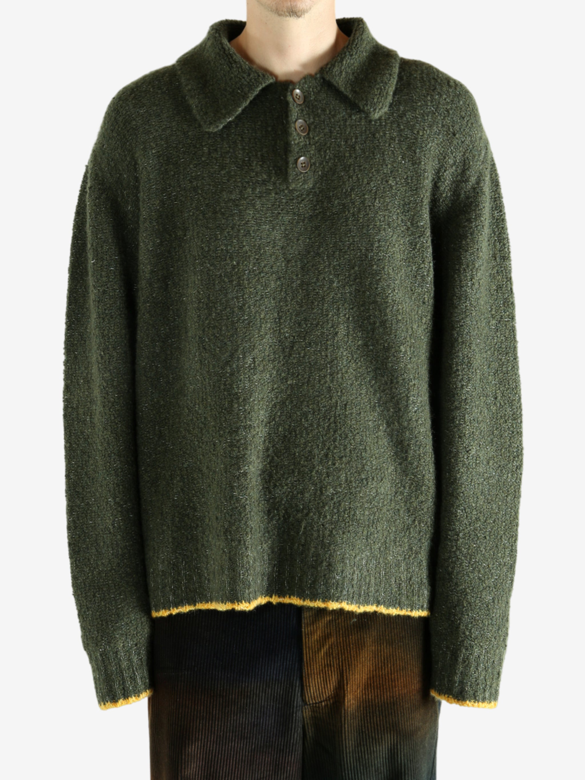 Green knitwear worn by a person, showing the knitwear's fit