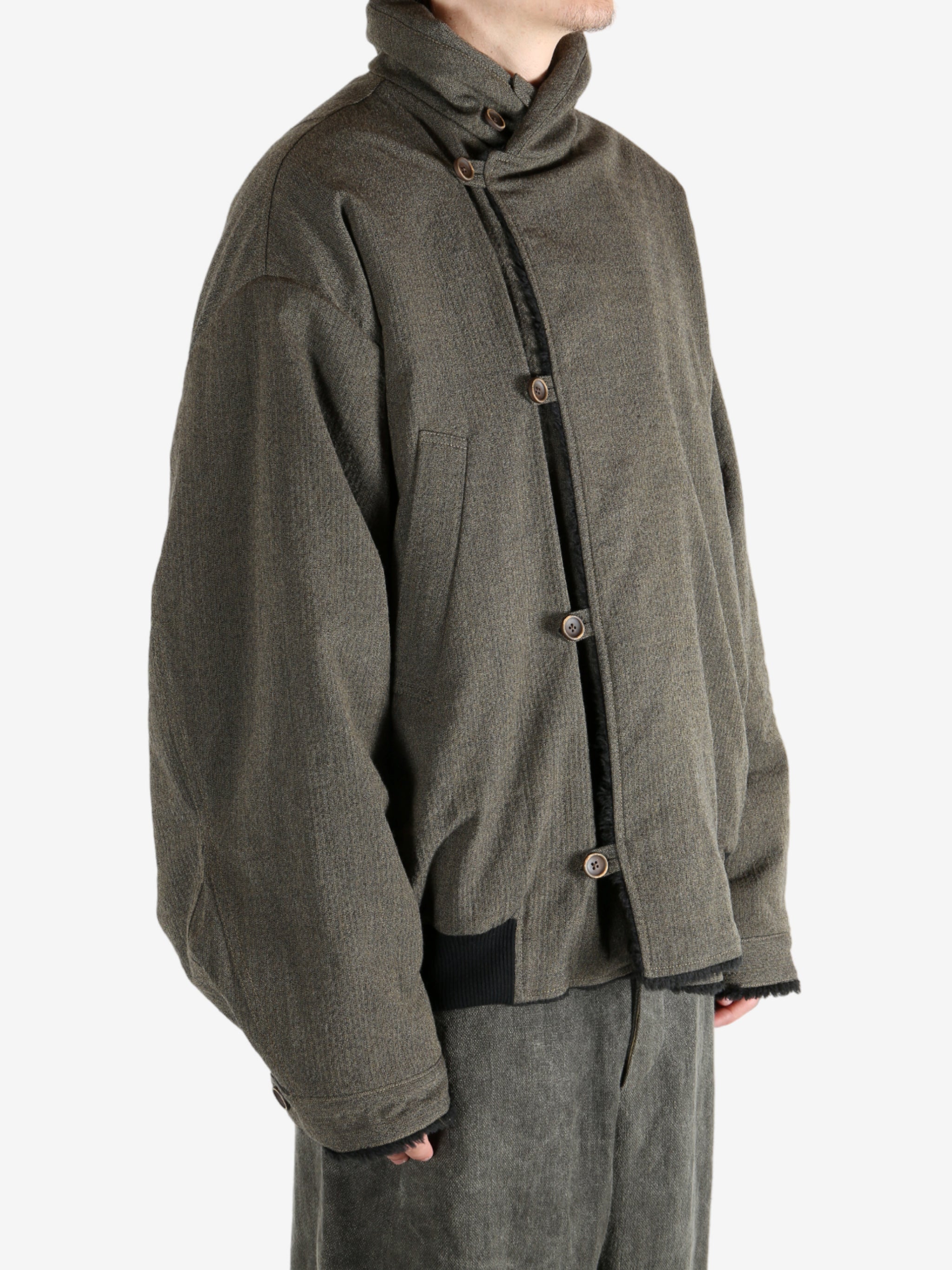 Green jacket worn by a person, showing the jacket's fit