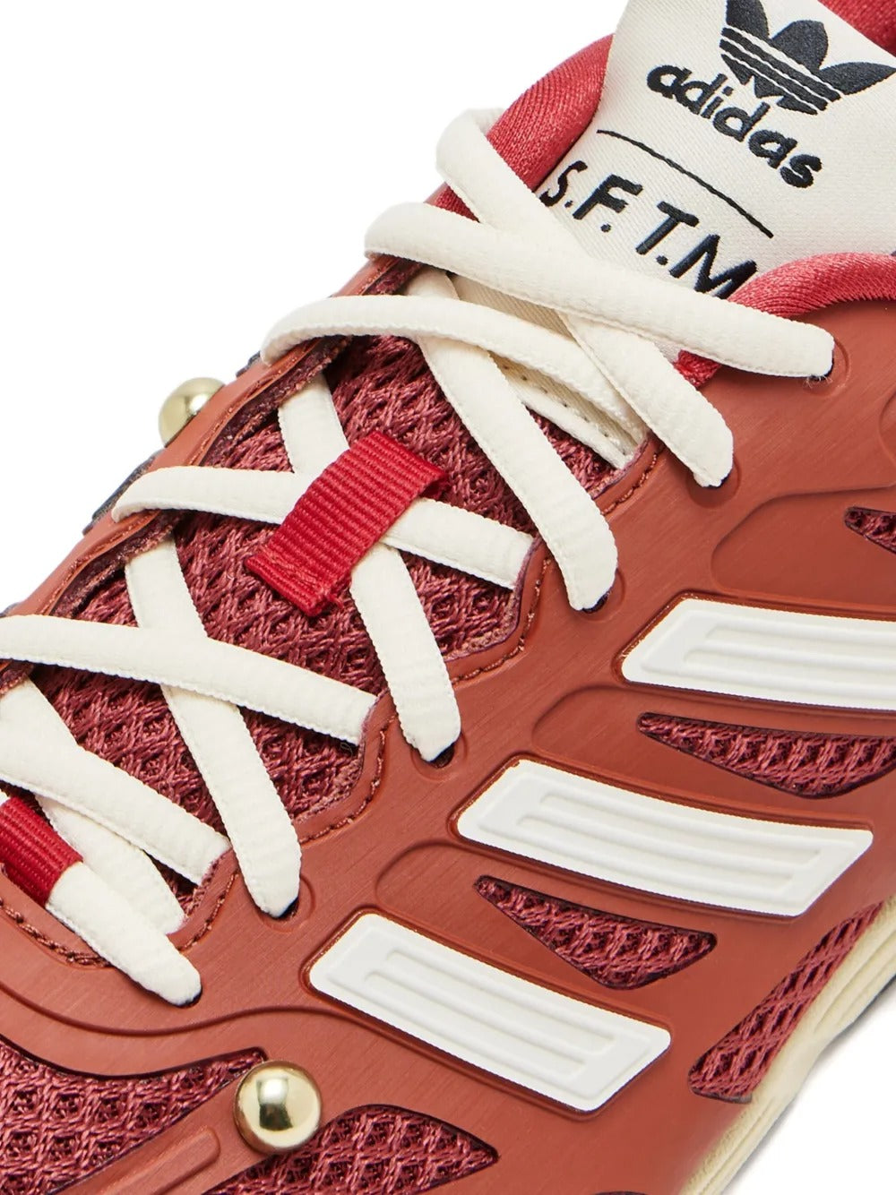 Close up of the red sneakers, showing texture of the mesh and polyurethane fabric