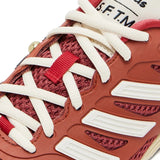 Close up of the red sneakers, showing texture of the mesh and polyurethane fabric