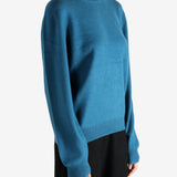 Blue sweater worn by a person, showing the sweater's fit
