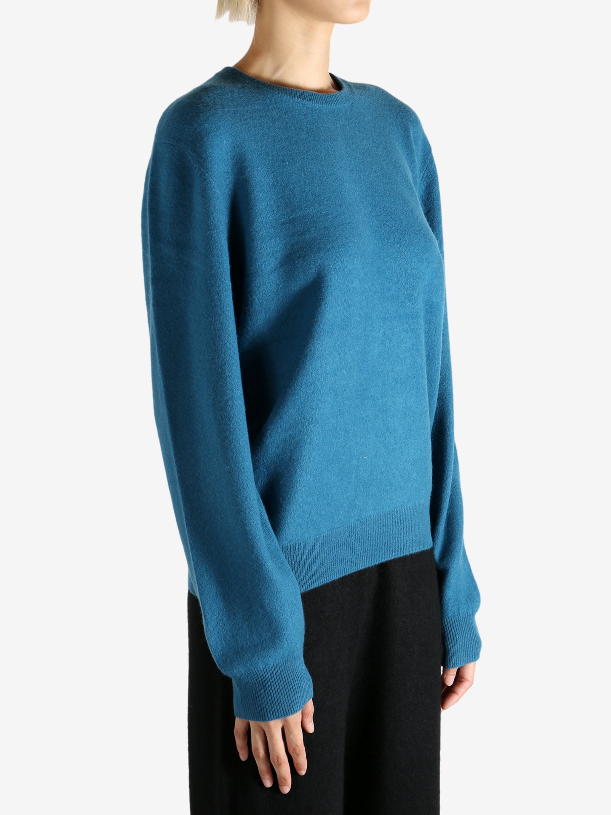 Blue sweater worn by a person, showing the sweater's fit
