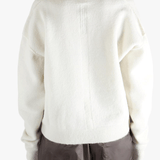 White sweater worn by a person, showing the sweater fit