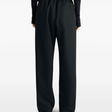 black pants worn by a person, showing the pants fit